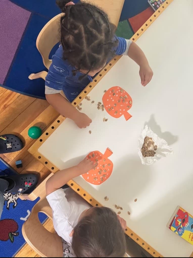 A teacher sitting with toddlers by the classroom library