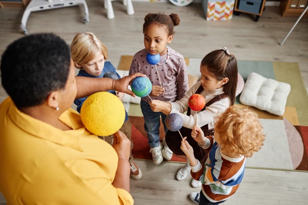 Preschoolers learning about the solar system with a teacher